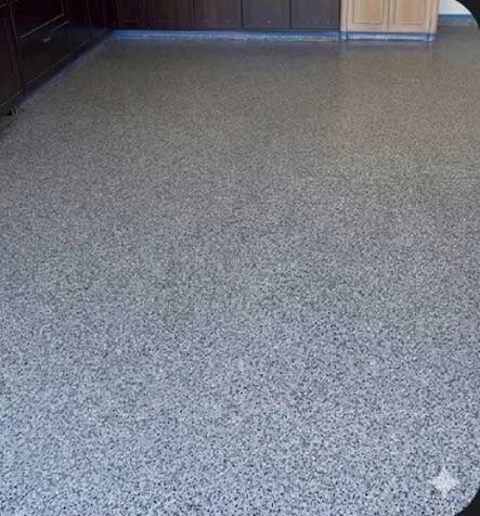 After: the same room finished in a pale grey flake epoxy floor with a clear topcoat.