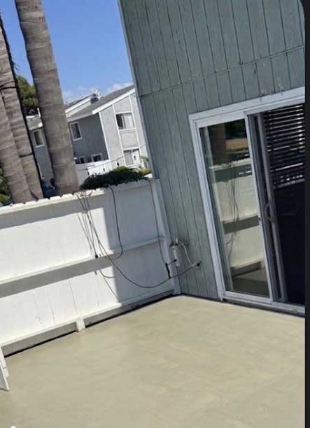 After: the same patio deck resurfaced in a clean, even sand-coloured coating.